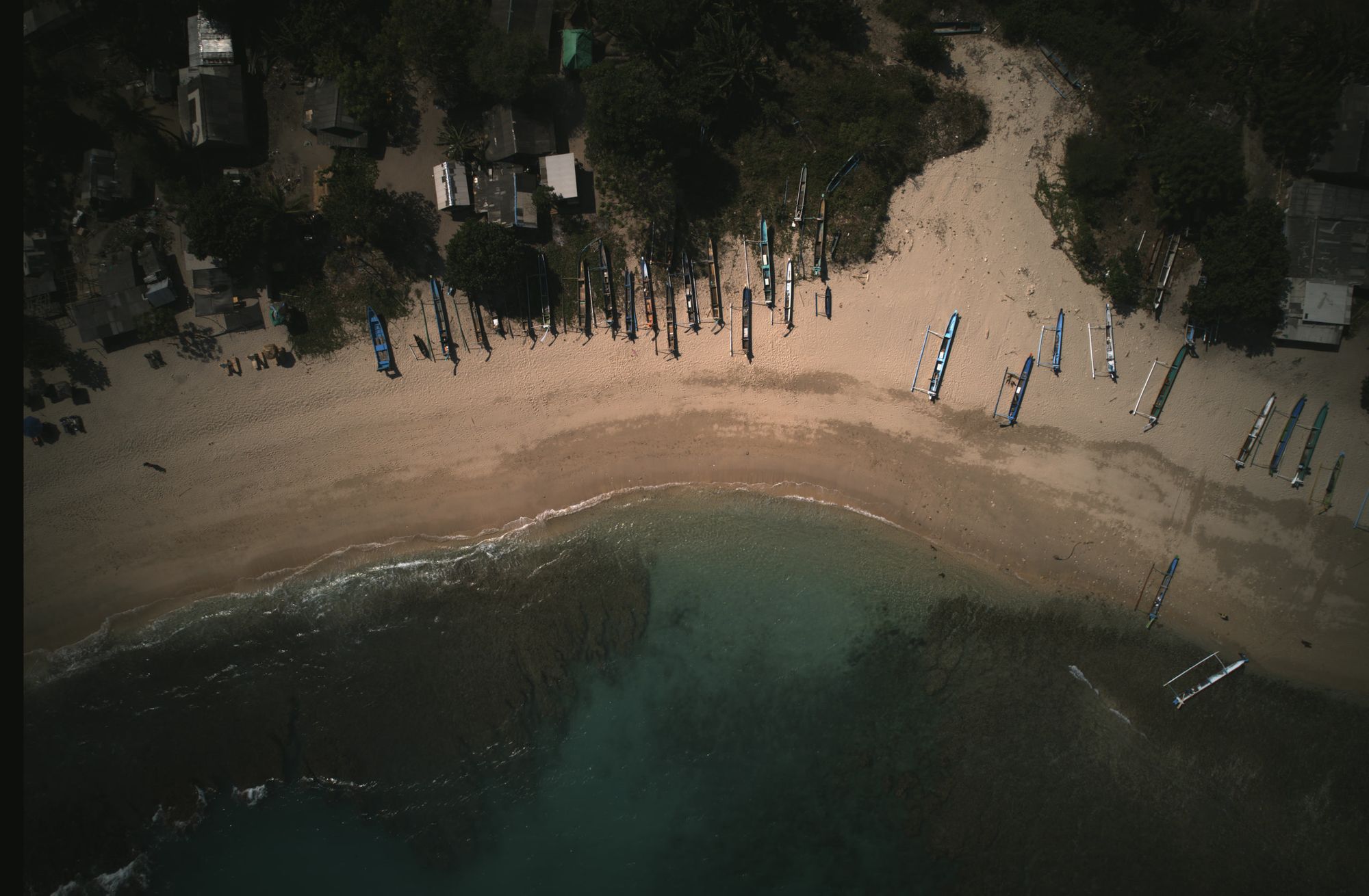 Empty crescent bay from a headland — turquoise water, pale sand