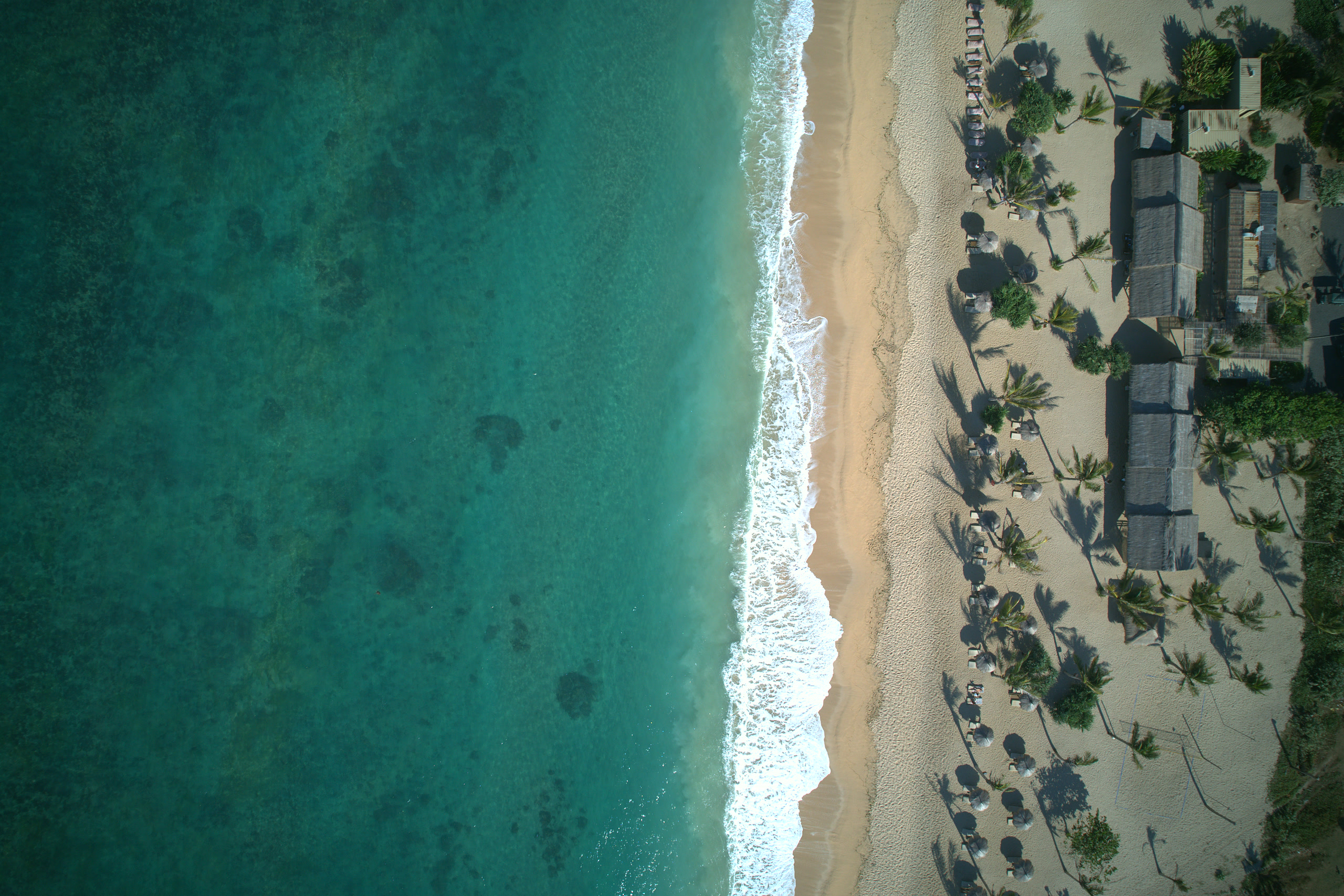 Aerial view of the South Lombok coastline — green headlands meeting turquoise sea
